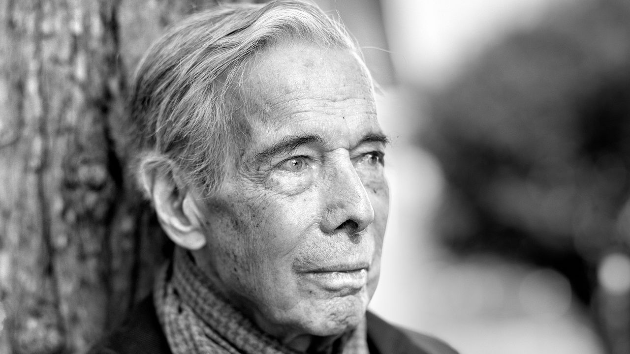 Portrait of writer Calvin Tomkins outdoors in a dark jacket and tie.