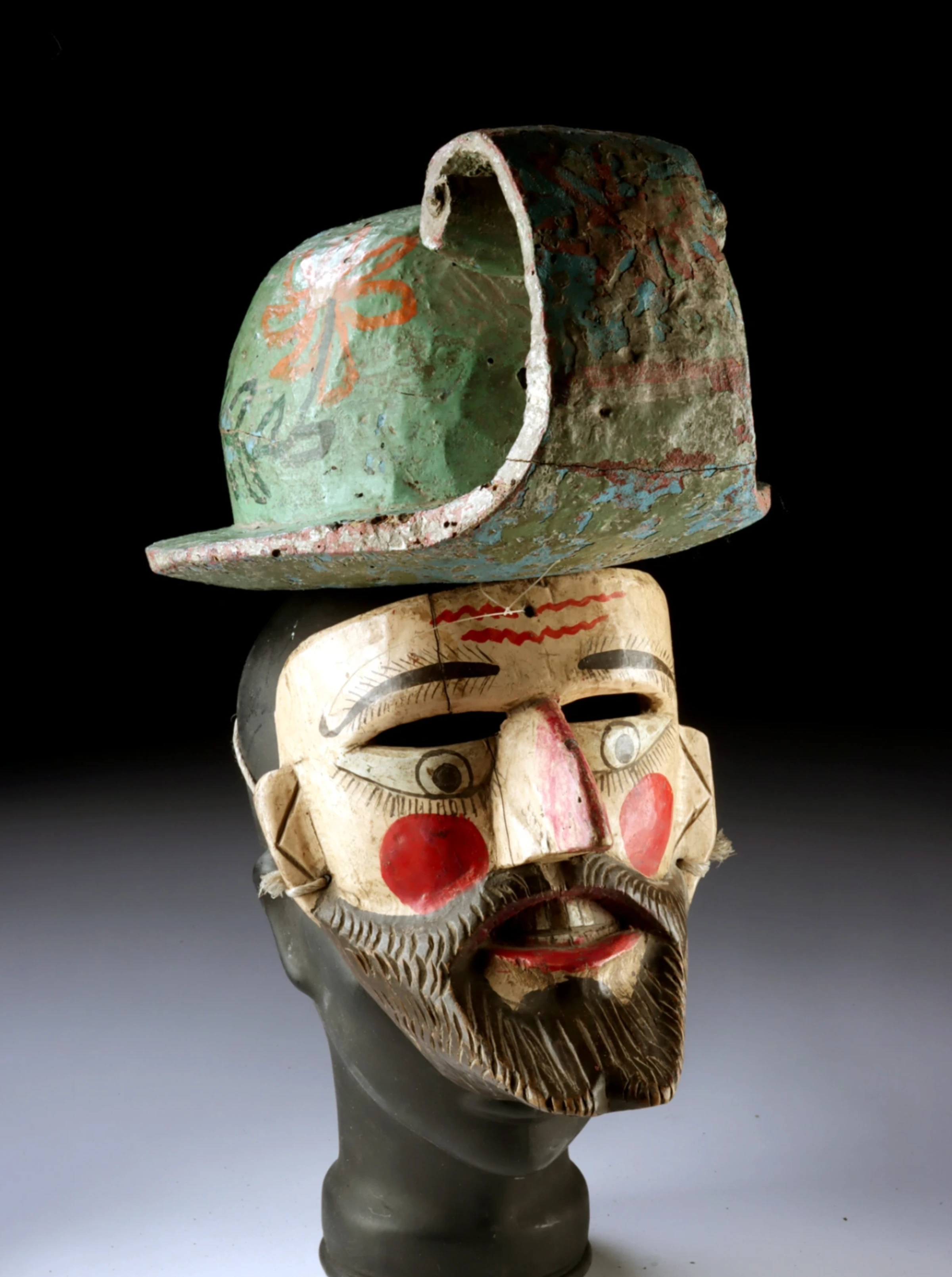 A carved Mexican Guerrero mask with helmet offered in an Artemis Fine Arts auction lot