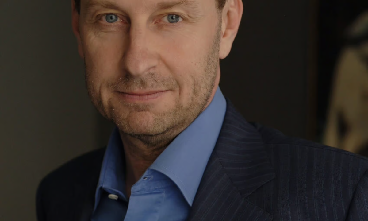 Dealer Yves Bouvier in a dark suit at a public event